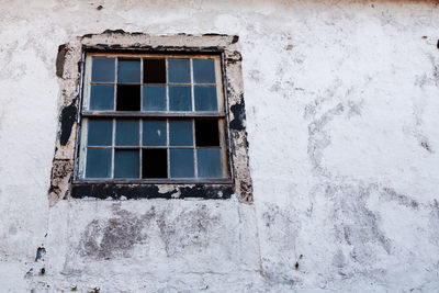 Low angle view of window on abandoned building