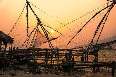 View of fishing net on shore against sky during sunset