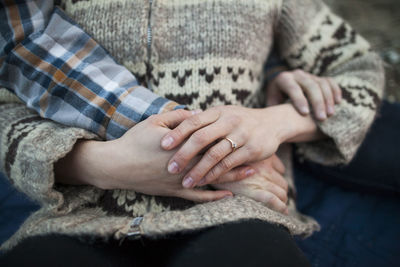 Cropped hand of boyfriend on girlfriend's stomach