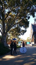 Rear view of people walking on street in city