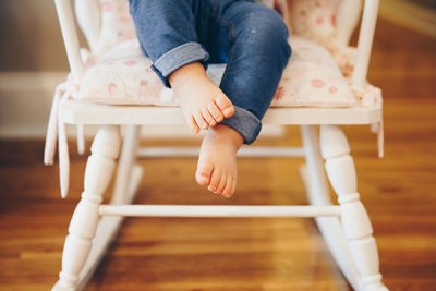 Low section of girl sitting on hardwood floor