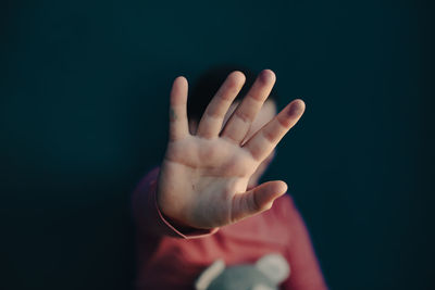 Close-up of human hand against black background