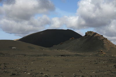 Scenic view of mountains against cloudy sky