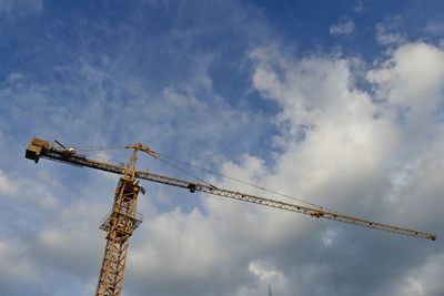 Low angle view of crane against sky