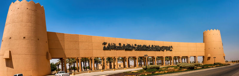 Text on building against clear blue sky