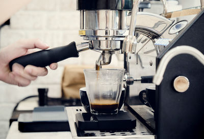Close-up of person pouring coffee in cafe