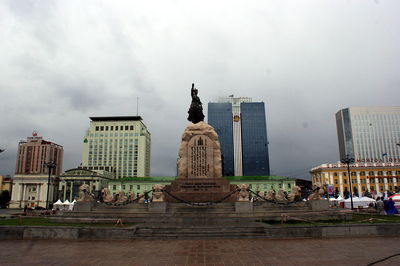 Statue of buildings against cloudy sky