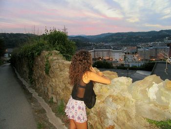 Silhouette of woman standing at sunset