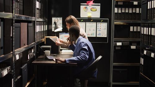 Rear view of woman sitting on shelf