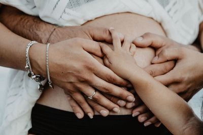 Cropped hands touching belly of pregnant woman