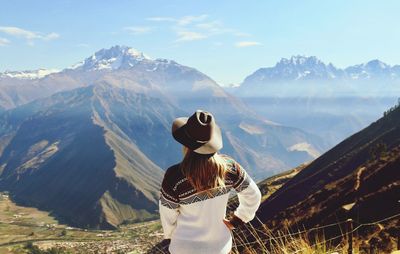 Rear view of woman in hat looking at mountains