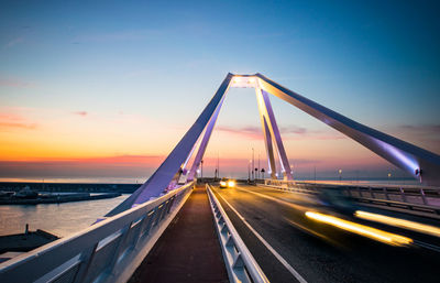 Bridge over sea against sky during sunset