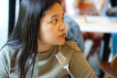 Close-up of woman looking away at restaurant