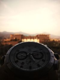 Close-up of clock against sky during sunset