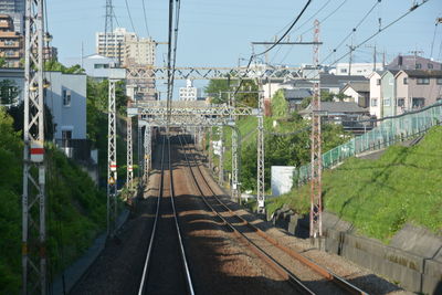 Railroad tracks amidst plants against sky