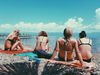 Rear view of people on beach against sky