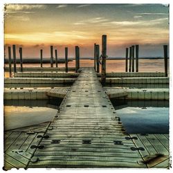 Pier on sea at sunset