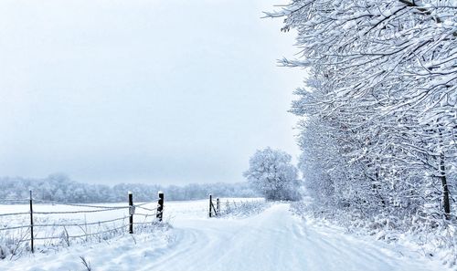 People on snow covered field against sky