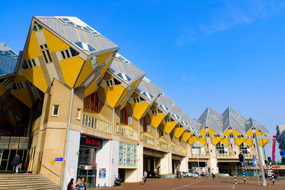 Low angle view of yellow building against blue sky