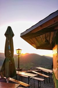 Scenic view of restaurant by mountains against sky during sunset