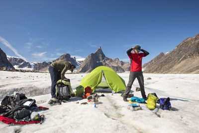 Panoramic view of people on snowcapped mountain against sky