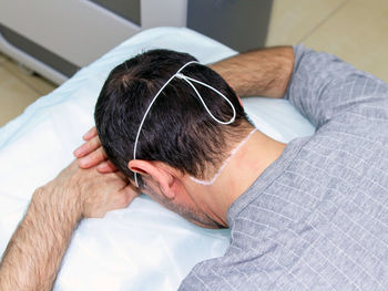 High angle view of man sleeping on bed