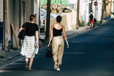 Rear view of women walking on footpath