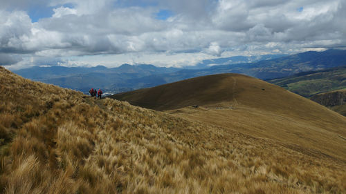 Tourists walking on a small path in the paramo in the ecuadorian highlands on a cloudy day