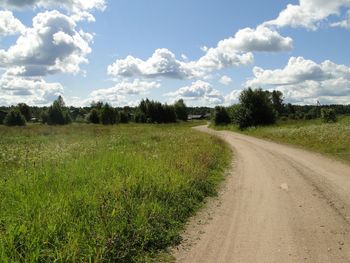 Road amidst field against sky