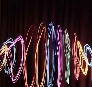 Low angle view of illuminated light trails at night