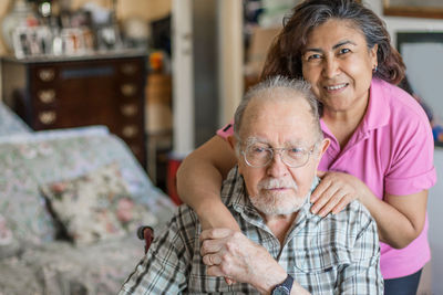 Portrait of smiling senior man with nurse at home