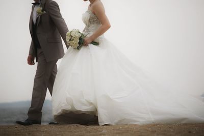 Bride and bridegroom walking at beach