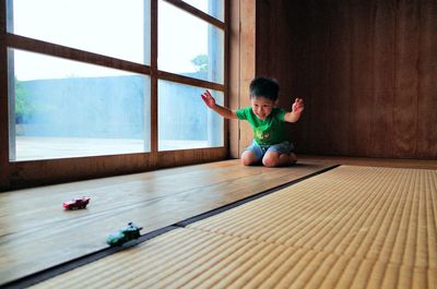 Cute boy playing with toy cars at home