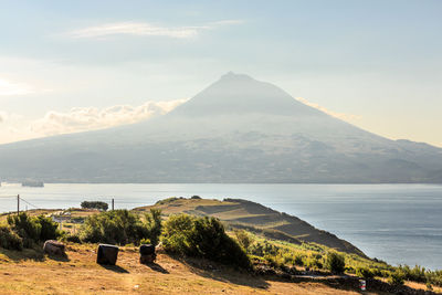 Scenic view of sea and mountains against sky