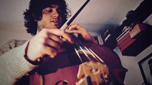 Close-up of man playing guitar