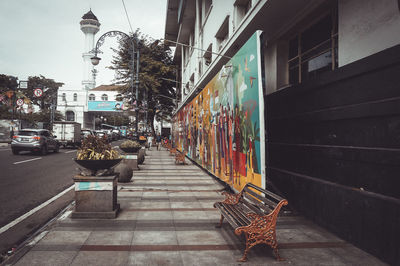 Sidewalk by street amidst buildings in city