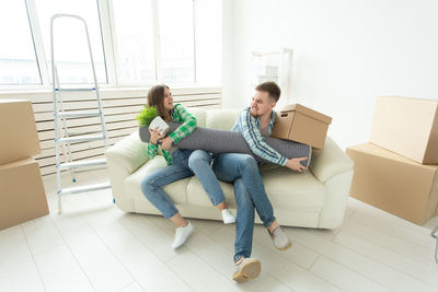 Young woman sitting on laptop in box