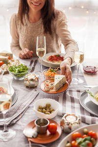 Midsection of woman keeping food on table