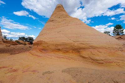 Low angle landscape of large yellow striped conical rock formation at ojito wilderness in new mexico