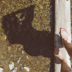 Low section of woman standing by water