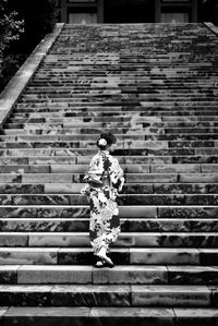 Rear view of woman walking on staircase