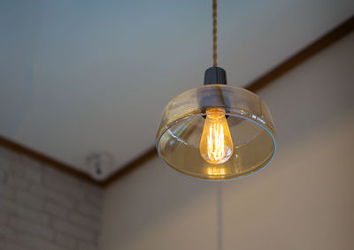 Low angle view of illuminated pendant light at home