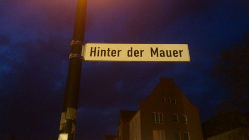 Low angle view of road sign against sky