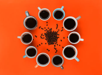 Directly above shot of coffee cup against orange background