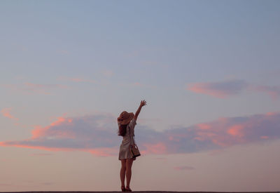 Full length of woman standing against sky during sunset