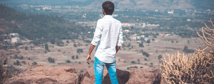 Rear view of man standing on rock