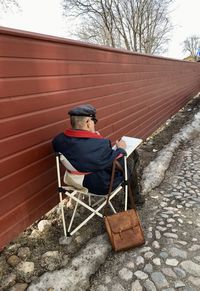 Side view of painter sitting on chair