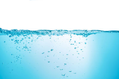 Close-up of water splashing against blue background