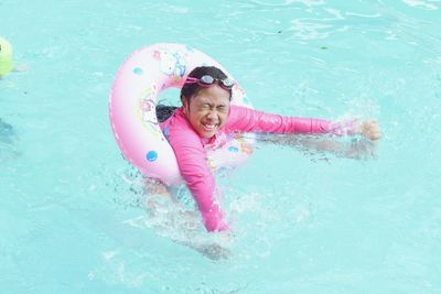 Girl with inflatable ring swimming in pool