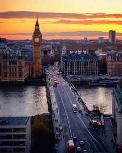 High angle view of bridge over river amidst buildings at dusk in city